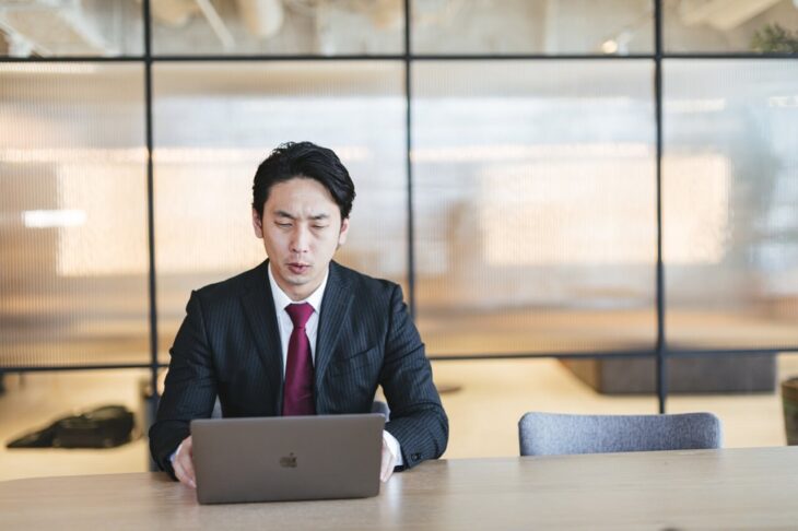 オフィスでパソコンに向かって仕事をする男性